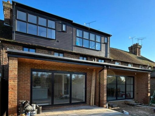 08551089-94b7-416c-aa41-216d5f8f1ffd-optimized Rear dormer loft conversion with full-width glazing and sliding doors on a terraced home.