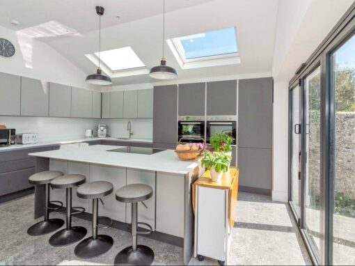9f39c898-181f-4fb6-9fa8-4b7e472ba385-optimized Contemporary kitchen with skylights, modern grey cabinetry, and island seating.