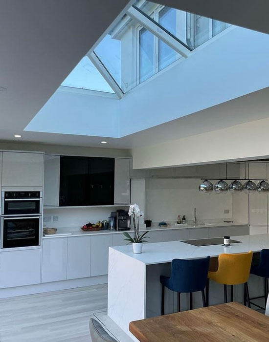 img-kitchens-550-700 Contemporary white kitchen with skylight and modern island seating.