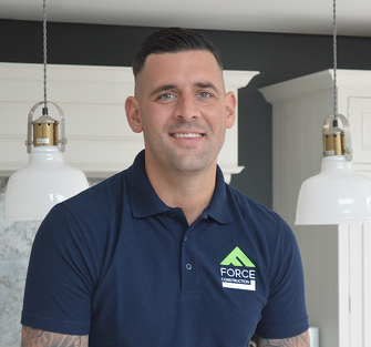 img-mat Mat from Force One Homes, an experienced carpenter with over 10 years in the trade, smiling in a modern kitchen setting, proudly representing the expert team behind high-quality home extensions and renovations across Sussex.