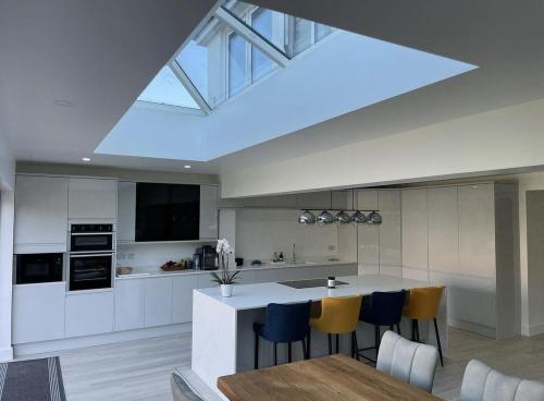 Contemporary kitchen extension with pitched skylight and breakfast island – Force One Homes project in West Sussex.