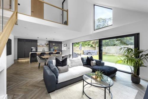 Open-plan living room with vaulted ceiling and full-height glazing – completed extension in Aldsworth, West Sussex.