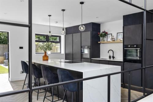 Contemporary black and white kitchen with island seating – Aldsworth extension project by Sussex builder.