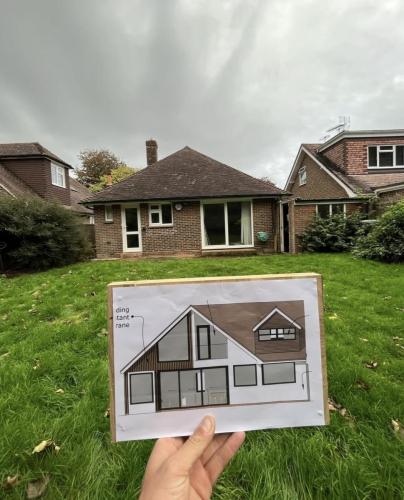 Planning design held up in front of original bungalow in Aldsworth, showing proposed extension and transformation.