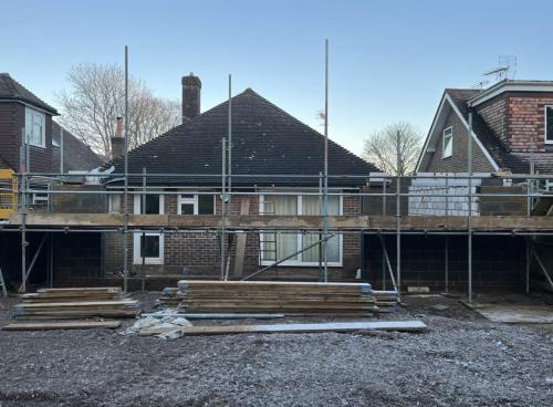 Rear view of Aldsworth property during loft and extension build, with scaffolding in place for upper structure work.
