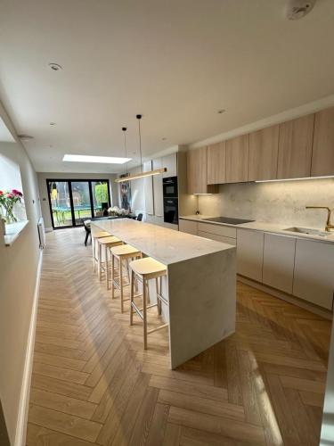 Contemporary kitchen extension with skylight, full-length island and herringbone flooring – part of Fenns Lane renovation.