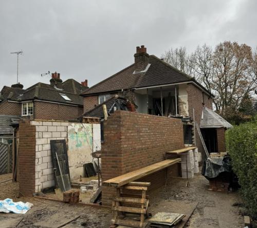 Rear view of Fenns Lane renovation showing upper-level works and brick extension under construction.
