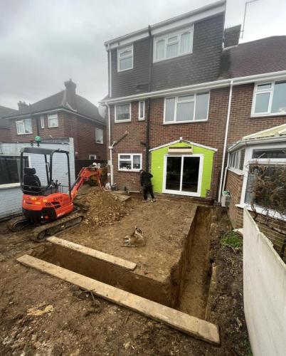 Excavation and groundwork in progress for new home extension in Nelson Road, Worthing, with mini digger on-site.