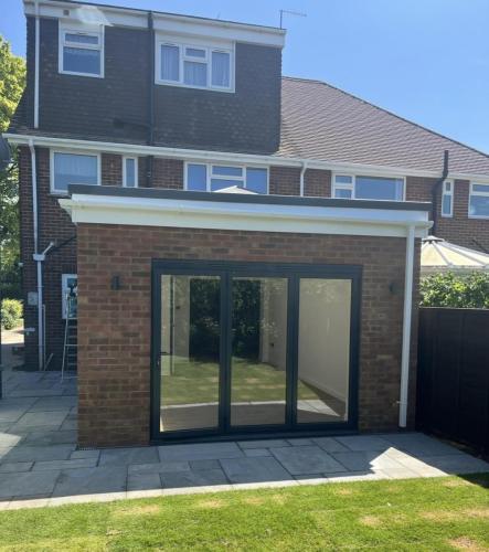 Rear view of completed brick extension with large black-framed bi-fold doors at a Nelson Road property in Worthing.