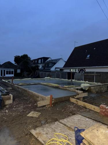 Concrete slab foundations set for new build property in Worthing, showing early-stage construction at dusk.
