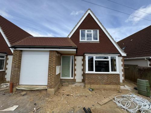 Completed exterior of detached new build home in North Avenue, Worthing, with garage and pitched roof.