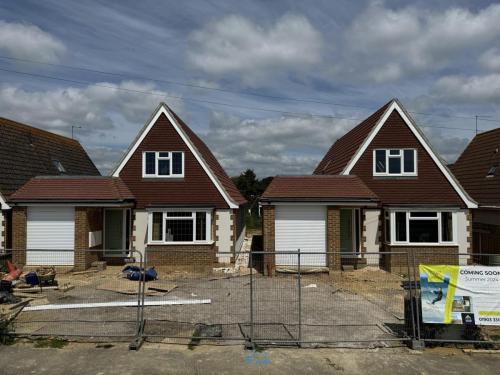 Three detached homes in North Avenue, Worthing, at advanced build stage with roofing and cladding nearly complete.