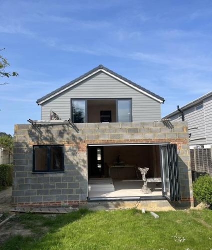 Open-plan rear extension build underway on Ocean Drive property – blockwork and upper floor structure visible.