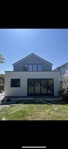 Rear garden view of modern home extension in Ocean Drive, Worthing – white render and full-width glazing.