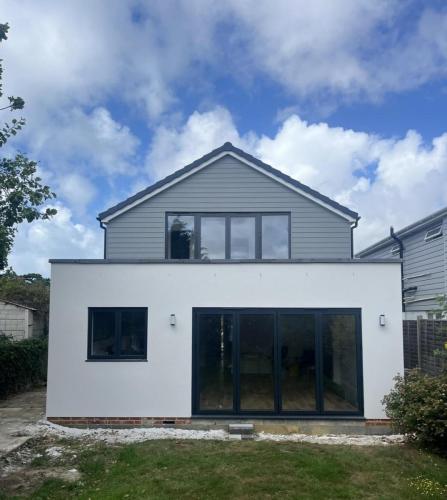 Contemporary extension with crisp white render and anthracite aluminium doors at Ocean Drive property in Worthing.