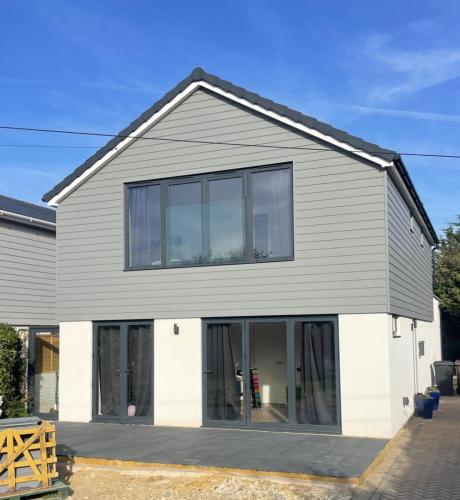 Completed two-storey extension with full-width glazing and modern grey cladding at Ocean Drive, Worthing home renovation.