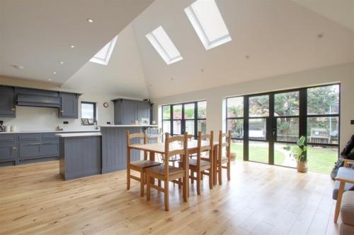Open-plan kitchen and dining extension in Wellesley Avenue, Worthing, with vaulted ceiling, skylights, and bifold doors.